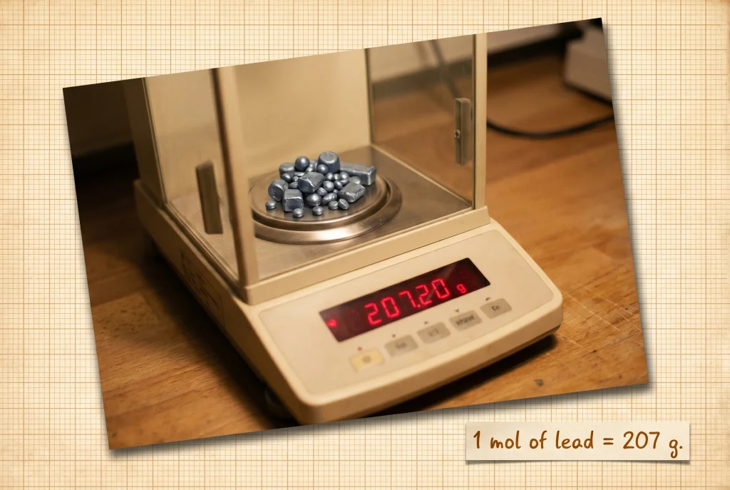 Analytical balance with one mole of Lead (Pb) on the weighing pan; the LCD reads approximately 207 grams.