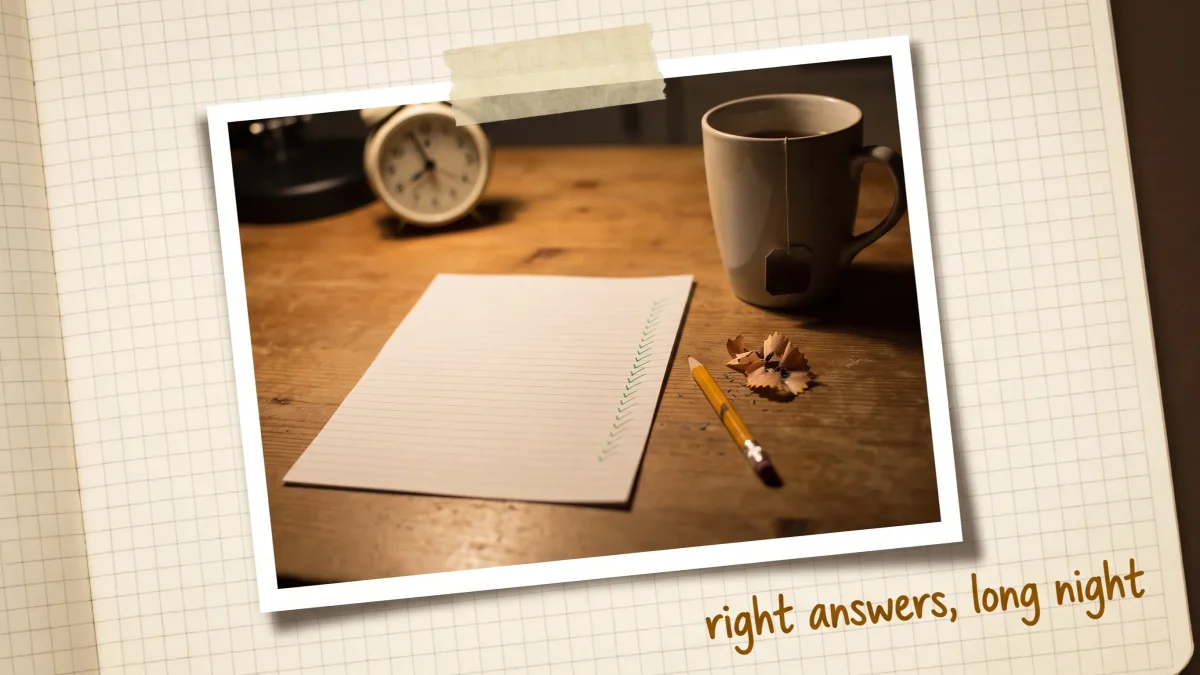 A finished homework page of green check marks on a kitchen table at night, beside a small alarm clock, a mug of tea, and pencil shavings